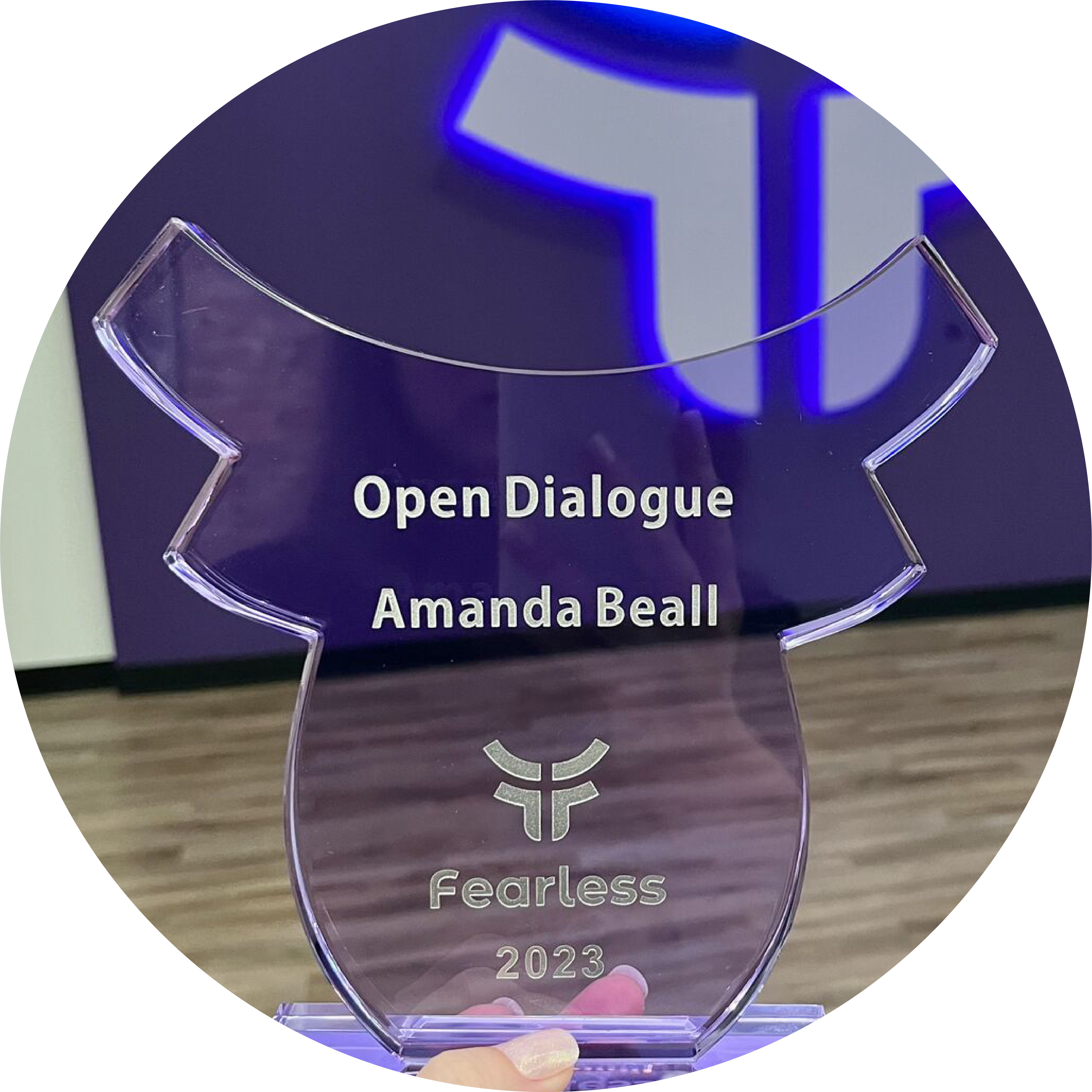 fearless-award Glass purple award with an engraving that says Open Dialogue Amanda Beall 2023. The award has Fearless's logo and the background is purple